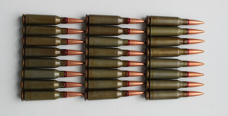 Live ammunition caliber 5.45 laid out six in a rows on a white surface top view