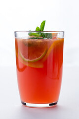 Red jumbo mug contains warm tea and limes. Tea spices