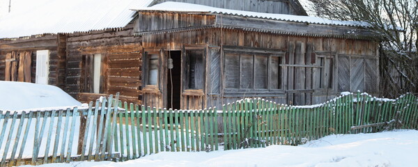 Abandoned farm wooden house in the snow