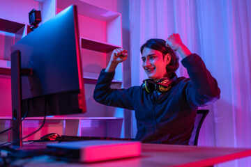 Handsome boy playing E-Sport game or streamer, Enjoying playing online games, Rejoices in victory, Live show play games, very happy, Blue and red lights