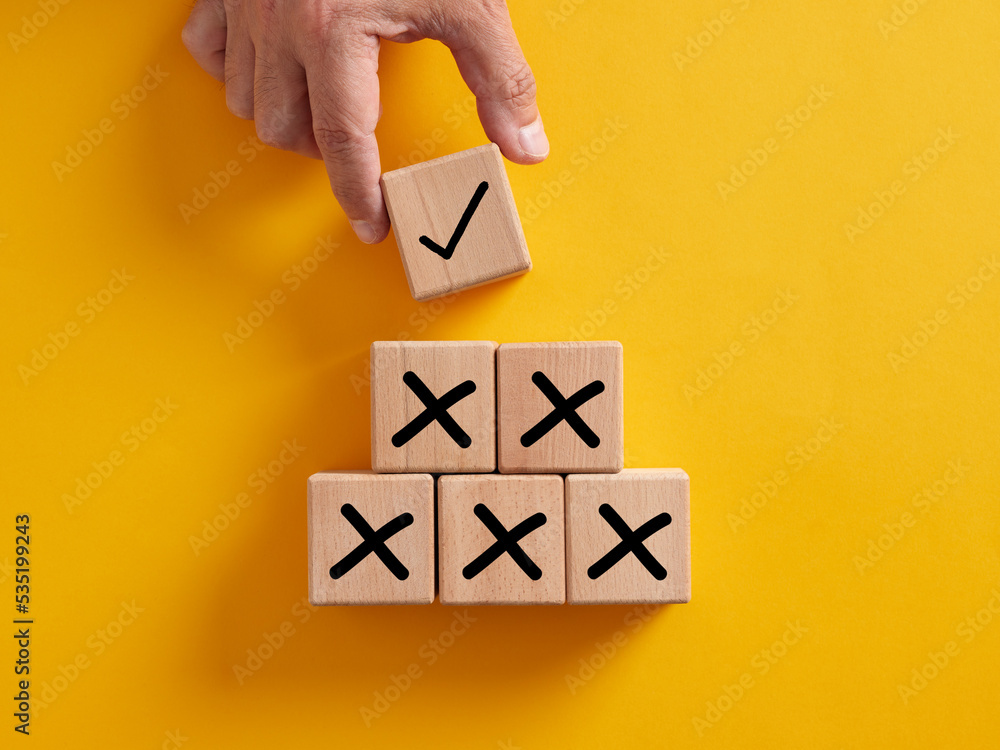 Poster hand putting wooden cube with tick checkmark right icon over the cross wrong icons.
