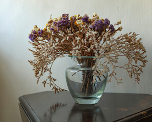 Bouquet of dried flowers in a glass vase on the table