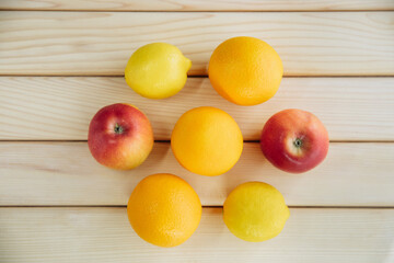 Lemon, apple, orange on a wooden white board