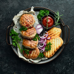 Fried Atriaux - ground pork wrapped in caul fat, swiss cuisine, handmade recipe. On a black stone background. Top view.
