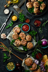 A set of fried meat, cutlets and shish kebab, handmade recipe. On a black stone background. Top view.