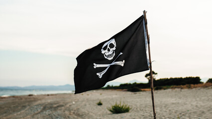 Pirates flag weaving on the beach - obrazy, fototapety, plakaty