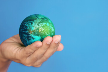 Hand hold globe with blue background.Elements of this image furnished by NASA