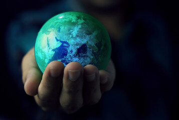 Hand hold globe with dark background.Elements of this image furnished by NASA