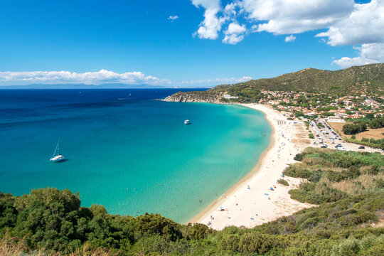 Aerial view on the beach Solanas with white sand, hills with green vegetation, sea with blue transparent water and village in the province Sinnai. Location Sardinia, Italy.
