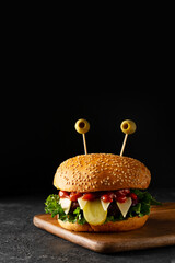 Funny party halloween monster burger on black background, halloween festive