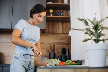 Woman cutting vegetables at the kitchen