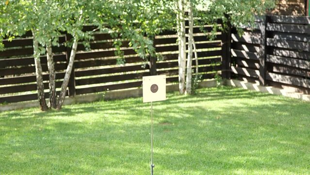 Paper target practice board with bullseye being penetrated by rubber bullet from a bb gun. Slow motion, no people