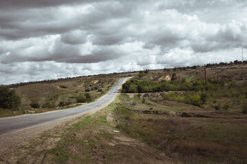 Gloomy sky hill track, autumn landscape. The track and the slope of the hill against the background of a gloomy sky