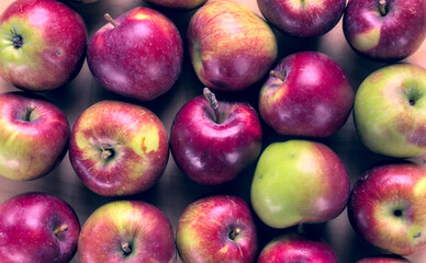 Concept for an simple autumn background. Close-up of fresh, organic apples on a wooden table. Flat lay, top view.