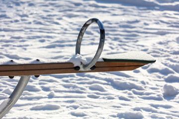 Children's swing in the snow in the park.