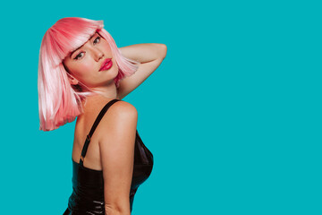 Profile portrait of a sensual young woman in pink wig, bob haircuts, she touches her neck, make up,...