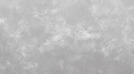 Small white snowflakes in winter as a background.