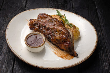 grilled meat with vegetables and spices on a black background
