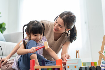 Asian beautiful loving mom play education game with daughter in house.