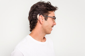 Obraz premium Young hispanic man wearing hearing aid isolated on white background
