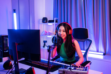 Asian young audio DJ woman sing a song on microphone to broadcasting.