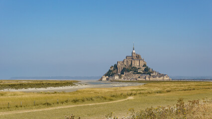 Beautiful view of famous historic Le Mont Saint-Michel tidal island with meadow landscape in...