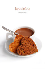 Cup of hot coffee with butter cookies in the shape of a heart on a white plate