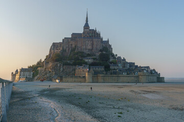 Le Mont Saint Michel at sunset during low tide on a summer evening seen from the bridge, Normandy,...