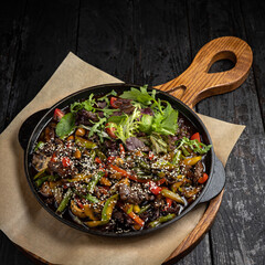grilled meat with vegetables and spices on a black background
