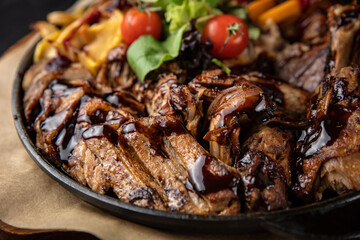 grilled meat with vegetables and spices on a black background
