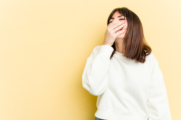 Young caucasian woman isolated on yellow background laughing happy, carefree, natural emotion.