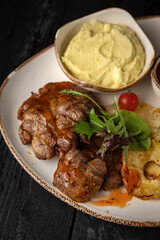 grilled meat with vegetables and spices on a black background
