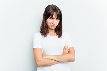 Young caucasian woman isolated on white background frowning face in displeasure, keeps arms folded.