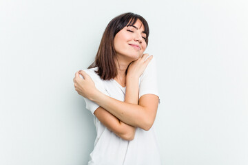 Young caucasian woman isolated on white background hugs, smiling carefree and happy.