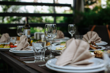 A table with beautiful dishes and prepared dishes on the summer terrace