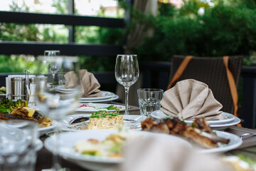 A table with beautiful dishes and prepared dishes on the summer terrace