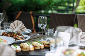 A table with beautiful dishes and prepared dishes on the summer terrace