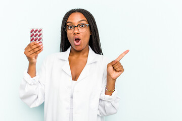 Young African American pharmacist woman isolated on blue background pointing to the side
