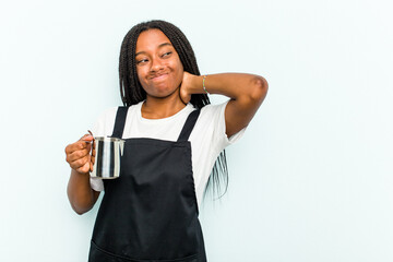 Young African American barista woman isolated on blue background touching back of head, thinking...
