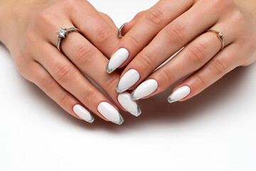 White manicure with silver. Ballero nail shape. Long nails on a white background close-up.