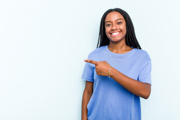 Young African American woman with braids hair isolated on blue background smiling and pointing aside, showing something at blank space.