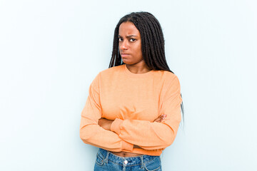 Young African American woman with braids hair isolated on blue background frowning face in...