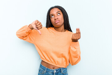 Young African American woman with braids hair isolated on blue background showing that she has no money.