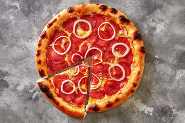 Sliced pizza with pepperoni, tomato sauce, mozzarella, onion and dough edge filled with cream cheese on gray background