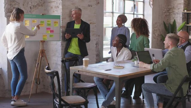 group of work at creative desk office department of a start-up enterprise - colleagues sharing ideas and discussing strategy