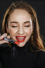 Obraz premium A girl with dark hair on a dark background with bright makeup