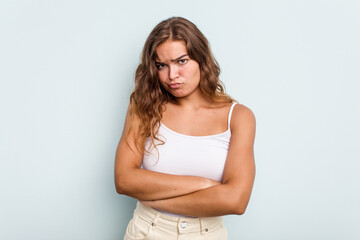 Young caucasian woman isolated on blue background unhappy looking in camera with sarcastic expression.