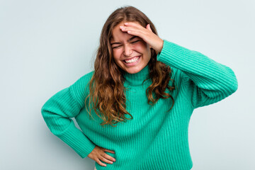 Young caucasian woman isolated on blue background joyful laughing a lot. Happiness concept.