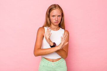 Caucasian teen girl isolated on pink background doing a denial gesture