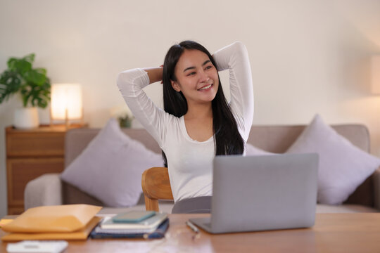 Beautiful Asian woman working at home relaxing by Stretching to relieve fatigue from sitting in the same place for a long time.